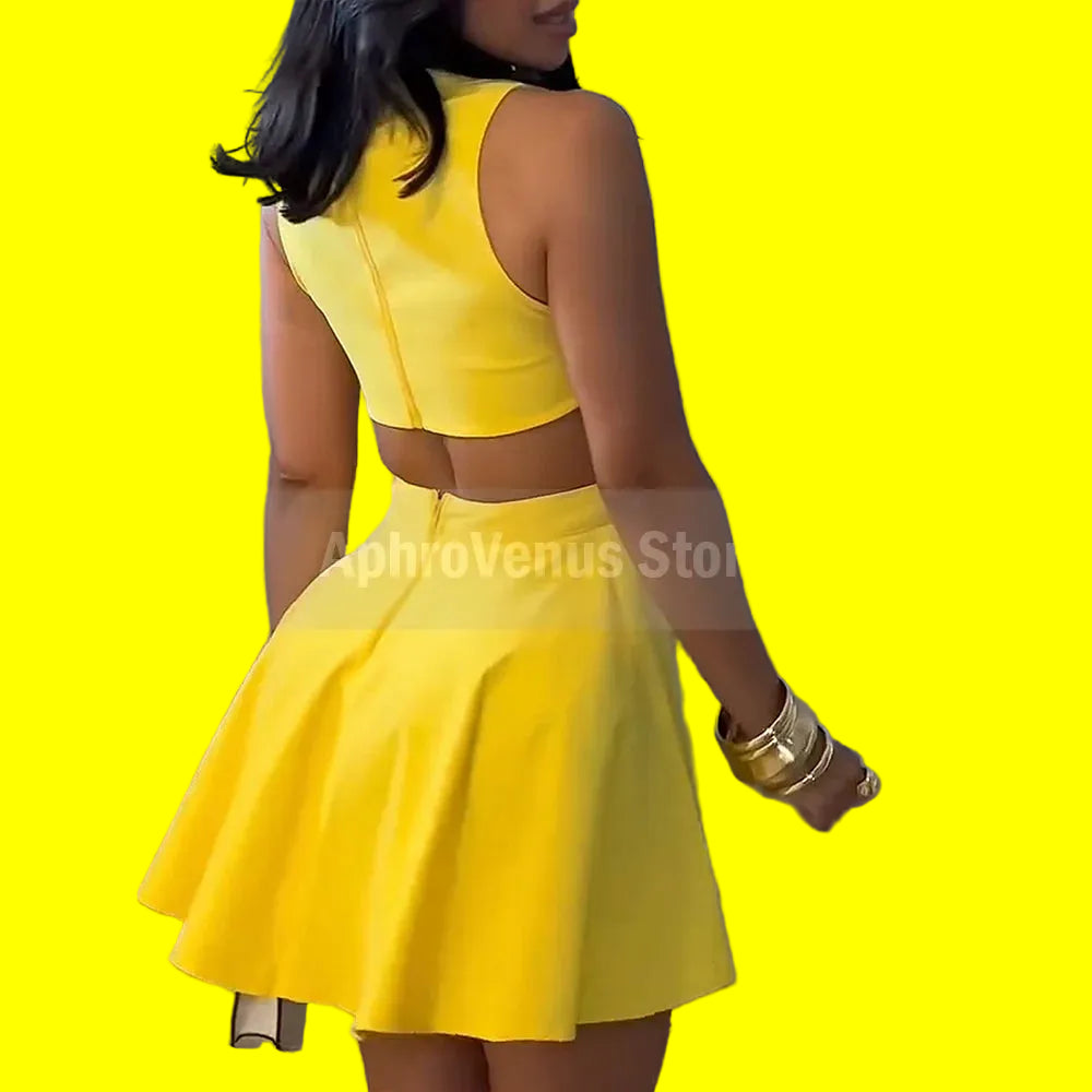 Yellow two-piece outfit worn by a person against a light gray wall..