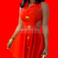 Red dress with gold buttons and a belt worn by a person, against a neutral background.